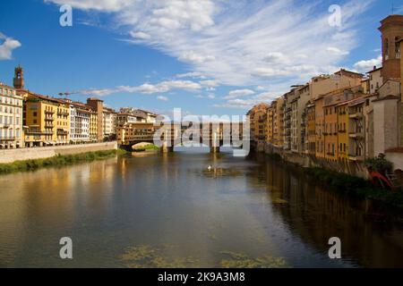 Ponte ad arco, il Ponte Vecchio a Firenze, case che si riflettono nel flusso d'acqua Foto Stock