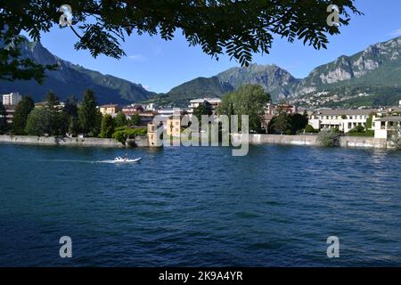 Lecco, Italia - 21 giugno 2020: Bella vista panoramica estiva del fiume Adda a Lecco con motoscafo in rapido movimento. Dal lago di Como al fiume Adda. Foto Stock