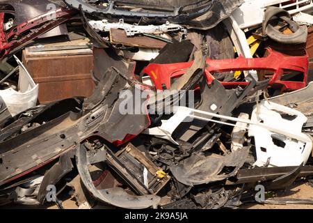 paraurti rotti e parti di automobili sulla strada come spazzatura Foto Stock