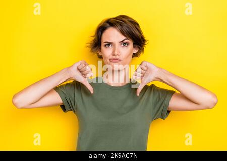 Primo piano foto di abbigliamento femminile insoddisfatto abiti alla moda cachi dare feedback negativo servizio ristorante isolato su sfondo di colore giallo Foto Stock