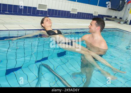 moglie e marito in preda al relax in piscina Foto Stock