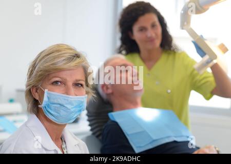 infermiera che regola la luce dentale in clinica Foto Stock
