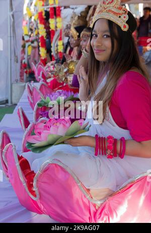 Un gruppo di giovani donne che tengono fiori di loto e che si siedono nello stesso momento alla celebrazione Diwali del 2022 a Richmond Hill, Queens, New York City. Foto Stock