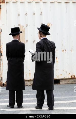 2 ragazzi ebrei ortodossi hanno una chiacchierata mentre sono in attesa di attraversare una strada. A Brooklyn, Neew York. Foto Stock