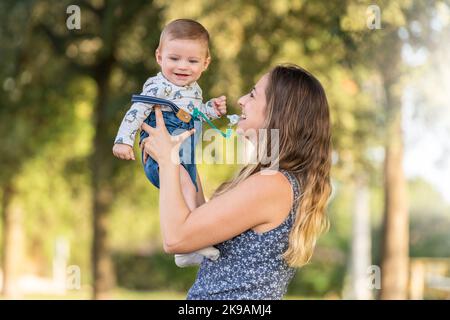 Madre e suo figlio nel parco guardando la macchina fotografica. Foto Stock