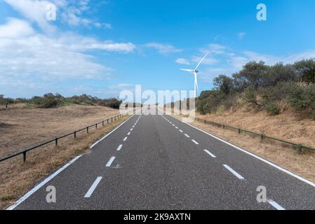 Strada di accesso alla spiaggia di Banjaard con turbine eoliche della barriera di Oosterschelde, Kamperland, Zeeland, Paesi Bassi, Europa Foto Stock