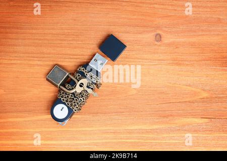 Unità flash avvolta in catene e fissata con un piccolo lucchetto. Concetto di privacy e protezione dei dati. Foto Stock