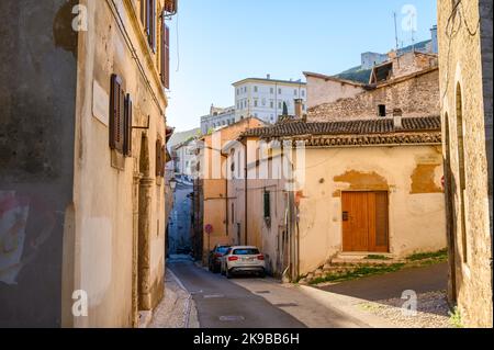 Una tipica scena di strada nel centro storico di Spoleto con case in pietra tradizionali e vicoli stretti fotografati la mattina presto. Umbria, Italia. Foto Stock