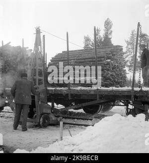 Caricamento del legname dall'autocarro al carro merci con dispositivo estrattore per il caricamento del legname, Glissjöberg. Foto Stock