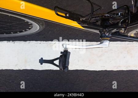 Una bici da corsa gialla e nera con un pedale lungo una linea Foto Stock