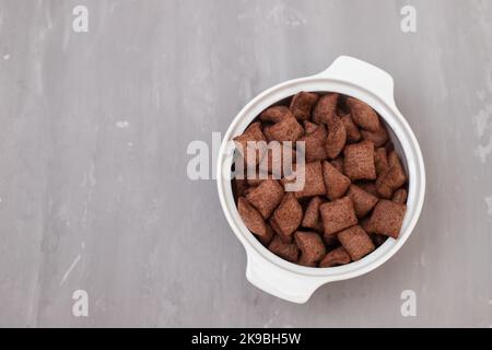 cereali al cioccolato in piccolo recipiente bianco su ceramica Foto Stock