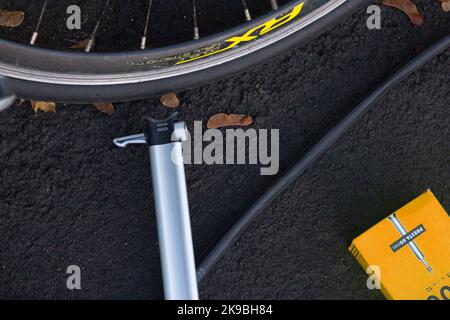 Una ruota per bicicletta, una pompa, un tubo interno e una nuova scatola Foto Stock