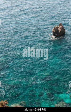 Corfù, Grecia .Vista dall'alto dell'acqua blu con una roccia solitaria. Foto Stock