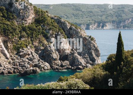 Corfù, Grecia. Splendido paesaggio con vista su montagne enormi e rocce grigie in acqua blu ricoperta di alberi verdi. Foto Stock