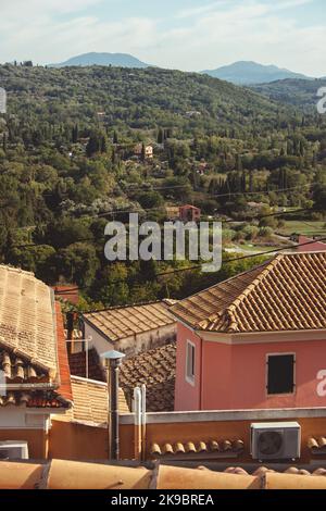 Corfù, Greece.View della città dall'alto. Potete vedere i tetti delle case e una casa rosa con un condizionatore d'aria bianco. Foto Stock