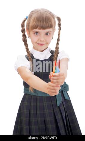 Ragazza con matite Una piccola scolaretta sembra buona in una divisa scuola. Una bella scolaretta con lunghi capelli scuri e un look affascinante. Foto Stock