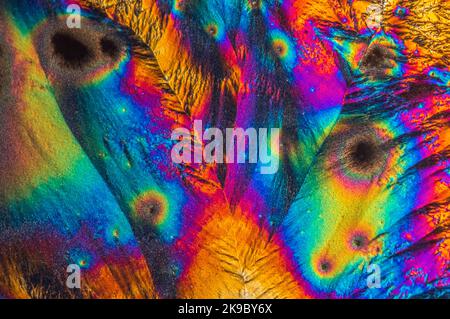 Macro fotografia estrema di cristalli di vitamina C che formano astratti modelli d'arte moderna, quando illuminati con luce polarizzata, sotto un microscopio Foto Stock