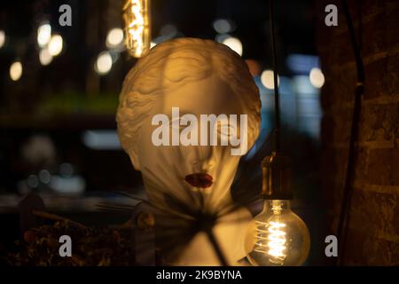 Scultura greca. Testa di donna in gesso. Statua in gesso. Dettagli interni. Lampada a incandescenza. Foto Stock