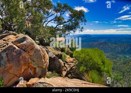 Vista da Tanderra Saddle lungo l'escursione di St Mary Peak, Wilpena Pound, Flinders Ranges, South Australia, con enormi massi in primo piano Foto Stock