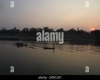 Naogaon, Bangladesh. 27th Ott 2022. Un pescatore che cattura il pesce durante il tramonto sul fiume Atria, sulla periferia del quartiere Dhamoir Hat di Naogaon. (Credit Image: © MD Mehedi Hasan/ZUMA Press Wire) Credit: ZUMA Press, Inc./Alamy Live News Foto Stock