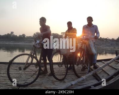 Naogaon, Bangladesh. 27th Ott 2022. I lavoratori attraversano il fiume Atria, dopo aver terminato il lavoro della giornata durante il tramonto nella periferia del cappello di Dhamoir del quartiere di Naogaon. (Credit Image: © MD Mehedi Hasan/ZUMA Press Wire) Credit: ZUMA Press, Inc./Alamy Live News Foto Stock