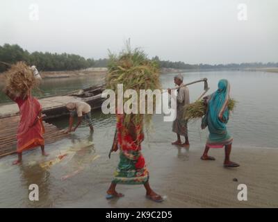 Naogaon, Bangladesh. 27th Ott 2022. Le persone che tornano a casa dopo la fine del giorno di lavoro vicino al fiume Atria nella periferia del cappello Dhamoir del quartiere di Naogaon. (Credit Image: © MD Mehedi Hasan/ZUMA Press Wire) Credit: ZUMA Press, Inc./Alamy Live News Foto Stock