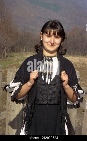 Gorj County, Romania, circa 2000. Giovane donna in un bel vestito tradizionale locale. Foto Stock