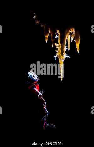 Speleologo che guarda le formazioni nella Grotte de la Toussaint, Francia Foto Stock