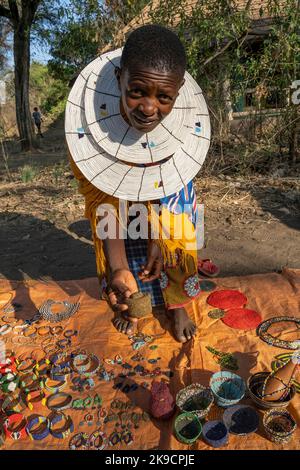 Tarangire, Tanzania - 12th ottobre 2022: Una donna Masai che vende gioielli fatti a mano e ornamenti su una strada all'alba. Foto Stock