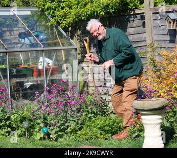 Uomo anziano che fa giardinaggio. Felice di essere in forma e godere del suo giardino. Foto Stock