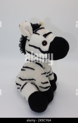 Carino nero e bianco peluche figura zebra, coccole giocattolo su sfondo bianco Foto Stock