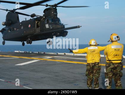 Un US Army MH-47 Chinook, assegnato al 160th Special Operations Aviation Regiment, parte dal ponte di volo a bordo della nave d'assalto anfibio USS Wasp (LHD 1) durante la qualifica di atterraggio del ponte della nave. L'MH-47 Special Operations Aircraft è un elicottero a lunga distanza, dotato di capacità di rifornimento aereo, di un sistema di ricarica a corda rapida e di altri aggiornamenti di attrezzature specifiche per le operazioni. Marina statunitense Foto Stock