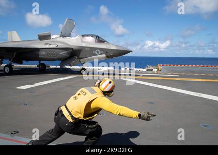 Aviation Boatswain’s Mate (Handling) 2nd Class estin Worfe, di San Antonio, segnala un aeromobile F-35B Lightning II assegnato a Marine Medium Tiltrotor Squadron (VMM) 262 (rinforzato) per il lancio dalla nave d’assalto anfibio USS Tripoli (LHA 7), 16 agosto 2022. Foto Stock