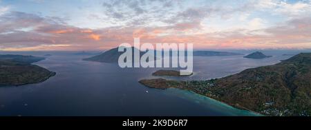 L'alba illumina Alor e i vulcani nello stretto di Pantar, Indonesia. Questa splendida regione è nota per la sua elevata biodiversità marina. Foto Stock