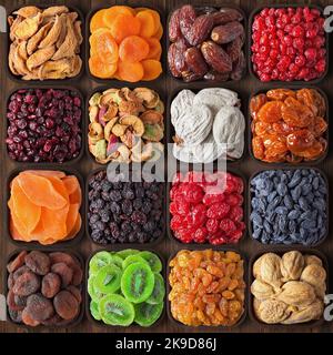 frutta secca assortita sfondo. variopinti mix alimentare: datteri, fichi, kiwi, papaia, ciliegia, albicocche, prugna secca, uva passa, mele, pere, pesca, persimmon, prugna Foto Stock