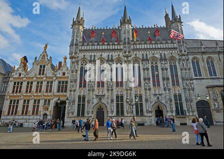Il Municipio di Bruges del 14th° secolo (Stadhuis) e Brugse Vrije, un edificio ornato del 18th° secolo con turisti e locali nella piazza della città. Foto Stock