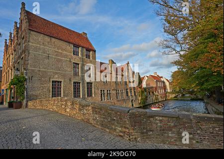 Case sul Meestraat a Bruges (Brugge) , Fiandre, Belgio, con una tipica strada acciottolata e ponte sul canale Groenerei. Foto Stock