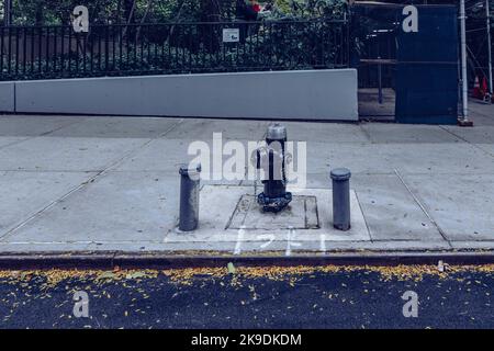 Classico idrante da fuoco in stile americano nero installato su un marciapiede di New York. Foto Stock