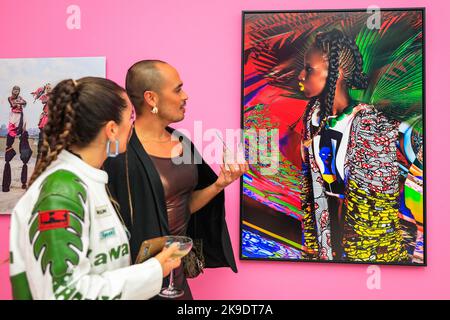Londra, Regno Unito. 27th Ott 2022. Un ospite guarda a NAMSA Leuba, Sarah, Lagos, Nigeria, 2015. Gli ospiti e gli artisti invitati si mescolano e si posano con le immagini. Vista privata della nuova mostra "The New Black Vanguard: Photography between Art and Fashion" alla Saatchi Gallery di Londra, con il sostegno di Burberry. La mostra comprende 15 fotografi neri internazionali ed è una celebrazione della creatività nera sia davanti che dietro la fotocamera, in esecuzione fino al 22 gennaio 2023. Credit: Imageplotter/Alamy Live News Foto Stock