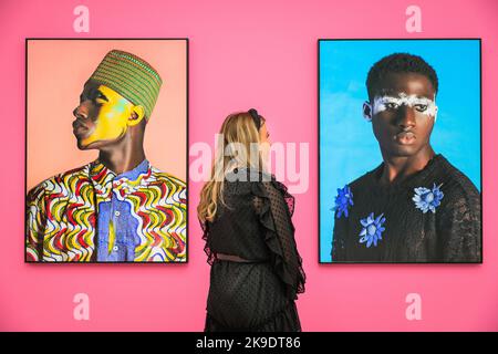 Londra, Regno Unito. 27th Ott 2022. Il personale posa con 'Untitled' di NAMSA Leuba (a sinistra) 2015, e 'Damien' (a destra), 2015. Gli ospiti e gli artisti invitati si mescolano e si posano con le immagini. Vista privata della nuova mostra "The New Black Vanguard: Photography between Art and Fashion" alla Saatchi Gallery di Londra, con il sostegno di Burberry. La mostra comprende 15 fotografi neri internazionali ed è una celebrazione della creatività nera sia davanti che dietro la fotocamera, in esecuzione fino al 22 gennaio 2023. Credit: Imageplotter/Alamy Live News Foto Stock