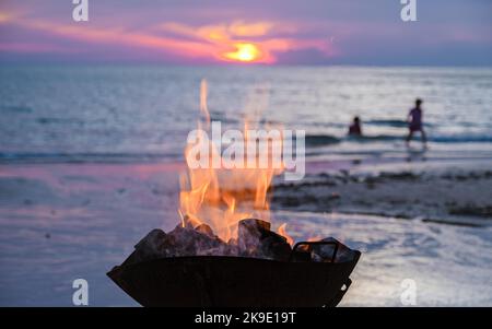 Cestino del fuoco durante il tramonto sulla spiaggia di Koh Chang Thailandia, spiaggia di sabbia bianca Koh Chang, camino durante il tramonto Foto Stock