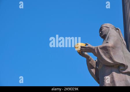 Una vista dettagliata, laterale, del profilo della Madre con la ciotola d'oro sulla colonna nera. Al memoriale dei difensori della Patria ad Astana, Nursultano, Kazak Foto Stock