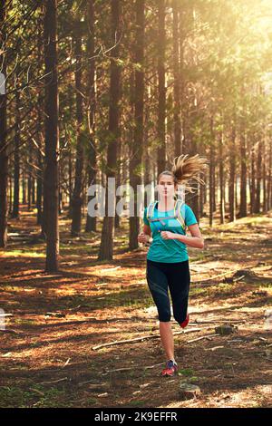 Theres bellezza dappertutto guardo. Una giovane donna fuori che funziona nella foresta. Foto Stock