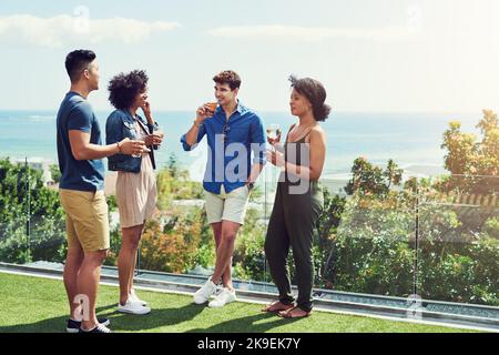Tutti sono stati amici per il tempo più lungo. Un gruppo di amici che bevono un drink e si divertono all'aperto durante le vacanze. Foto Stock