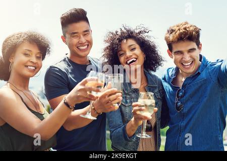 Grazie a tutti. Ritratto di un gruppo di amici che bevono un drink e che condividono un brindisi all'aperto mentre sono in vacanza. Foto Stock