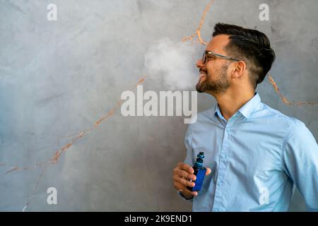 Fumatori e vaping può essere malsana e coinvolgente e rappresentano un rischio per la salute dei polmoni Foto Stock