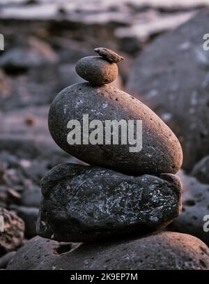 Pietre equilibrate l'una sull'altra per costruire un cairn alla spiaggia Foto Stock