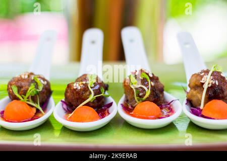 Polpette di carne agrodolce su cucchiai di ceramica presso un buffet dell'hotel a Cebu, Filippine Foto Stock