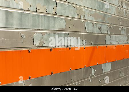 Vecchia parete con striscia arancione. Dettagli dell'edificio. Trama della superficie diagonalmente. Vernice rovinata. Foto Stock