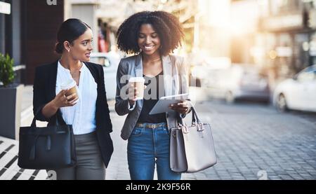 Fare loro il successo un passo alla volta. Due donne d'affari che hanno una discussione mentre camminano nella città. Foto Stock